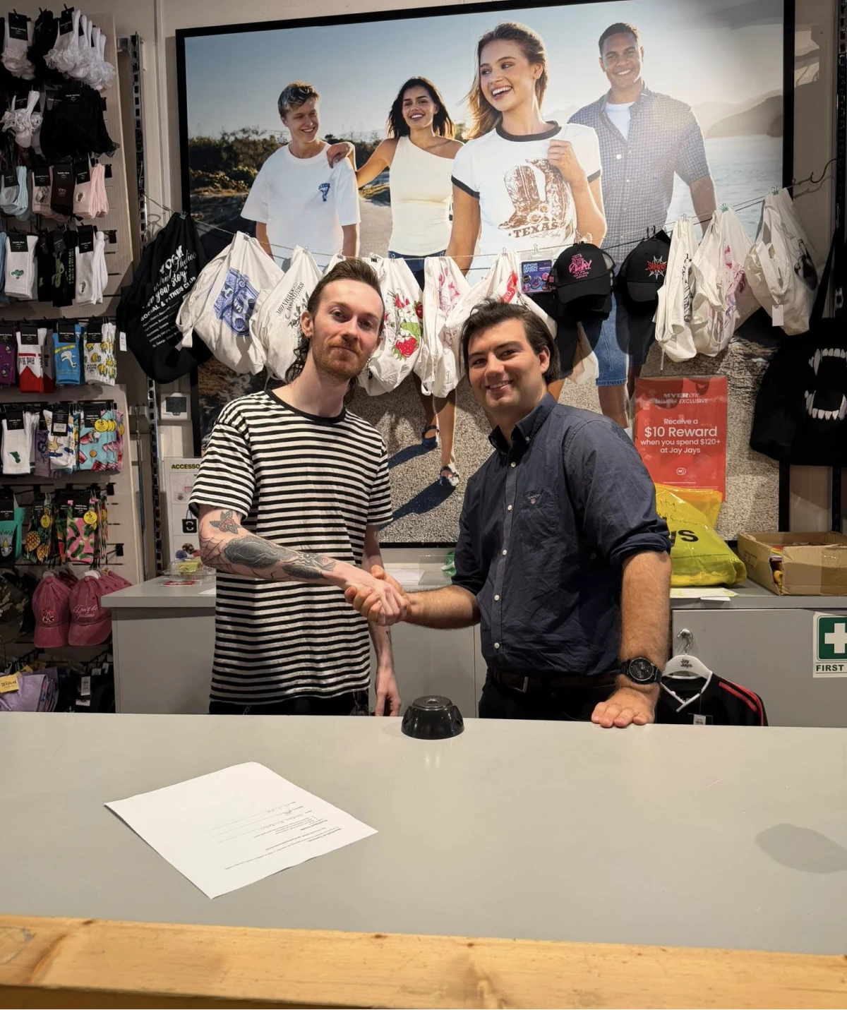 Two men shaking hands in store.