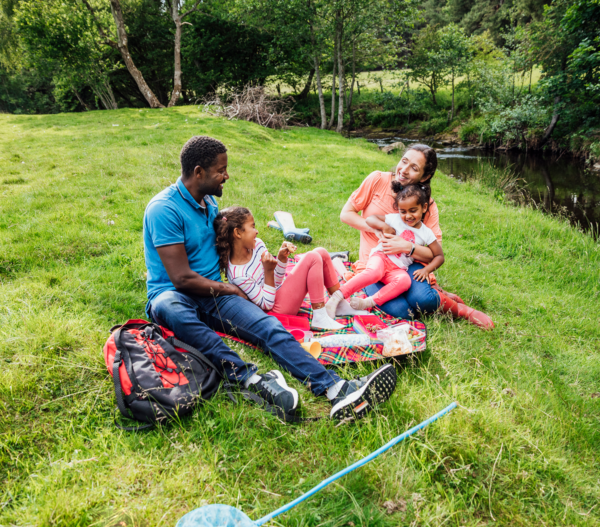 Family enjoying picnic by a riverside.