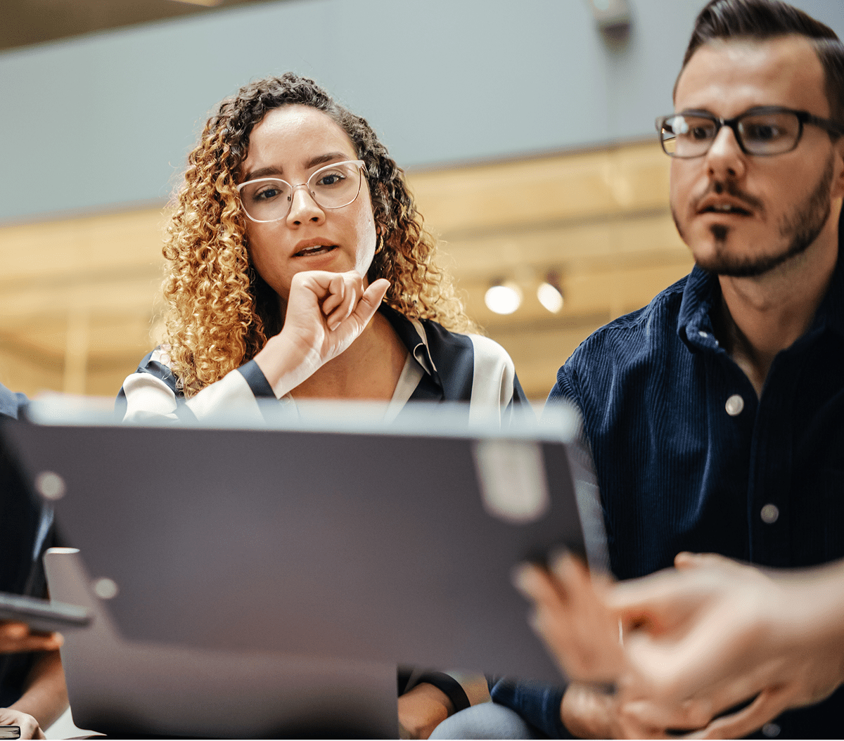 People collaborating while viewing a laptop screen.