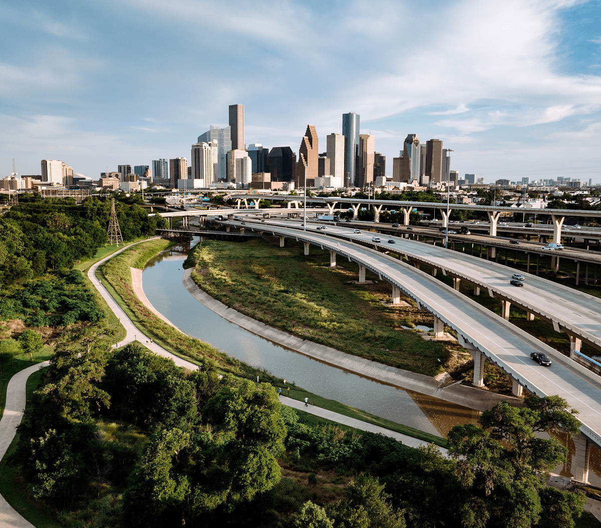 Houston skyline with highways and greenery.