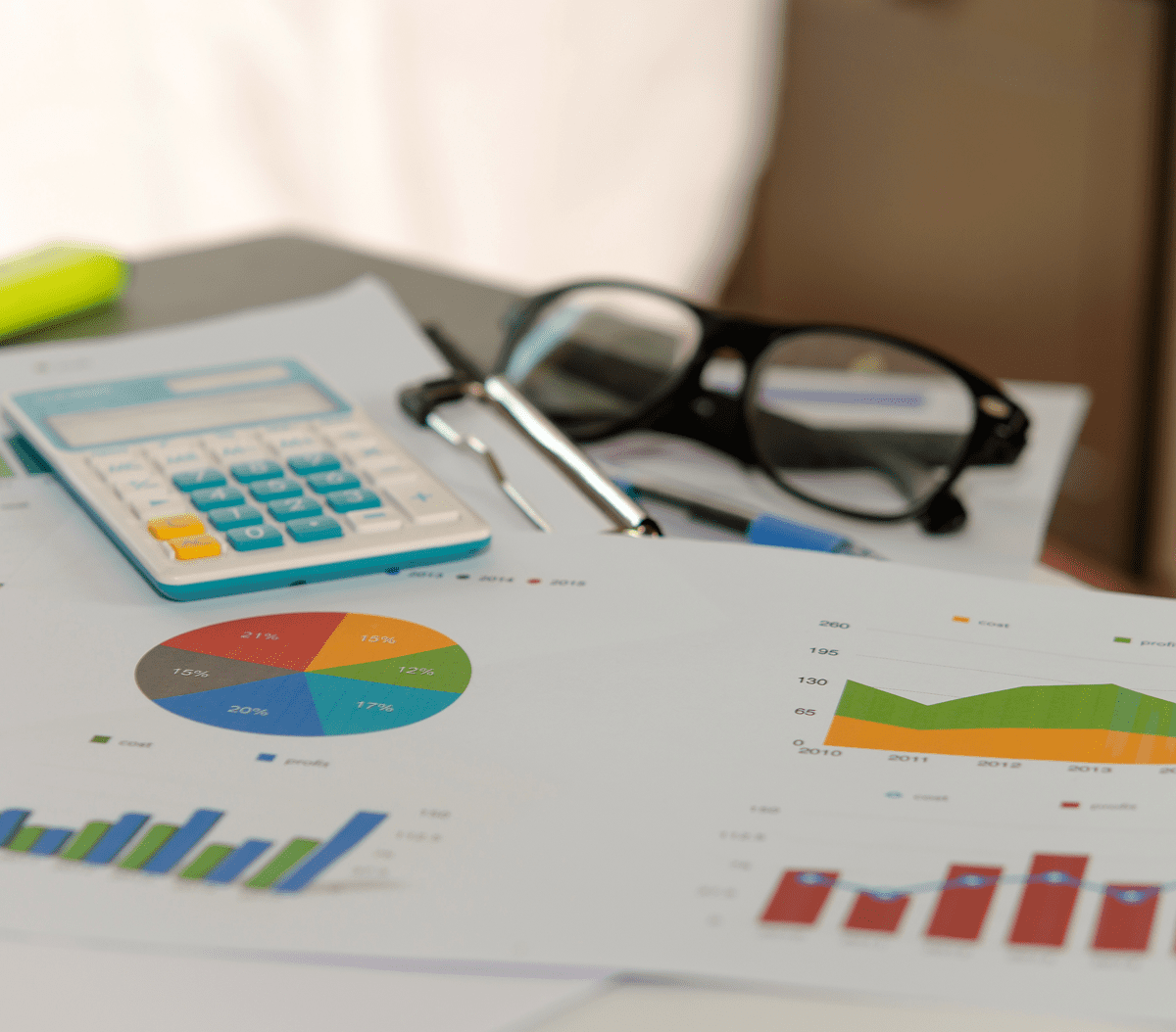 Calculator and charts on a desk.