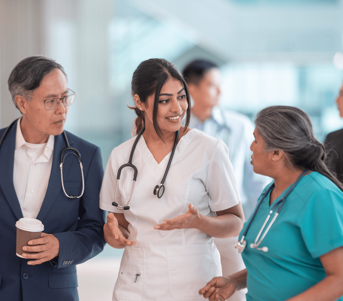 Healthcare professionals discussing in hospital corridor.