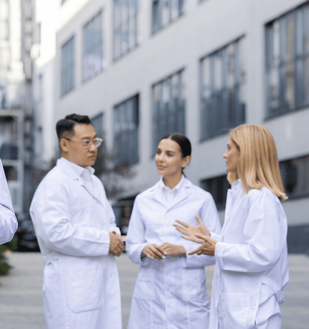 Scientists discussing outside modern research facility.
