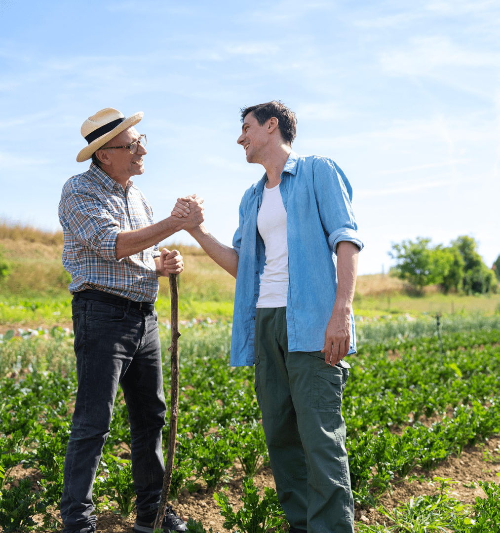 Two men shaking hands in a field.