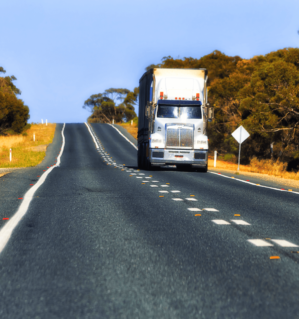 Truck driving on a rural highway road.