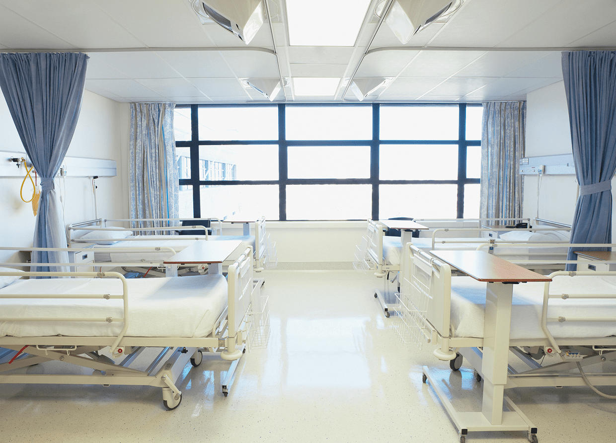 Hospital ward with empty patient beds.